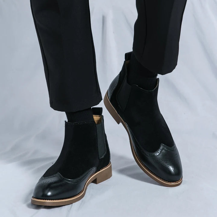 Black Chelsea boots worn with tailored trousers