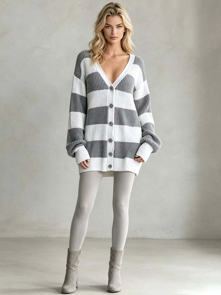 Woman wearing grey and white striped oversized cardigan sweater with boots