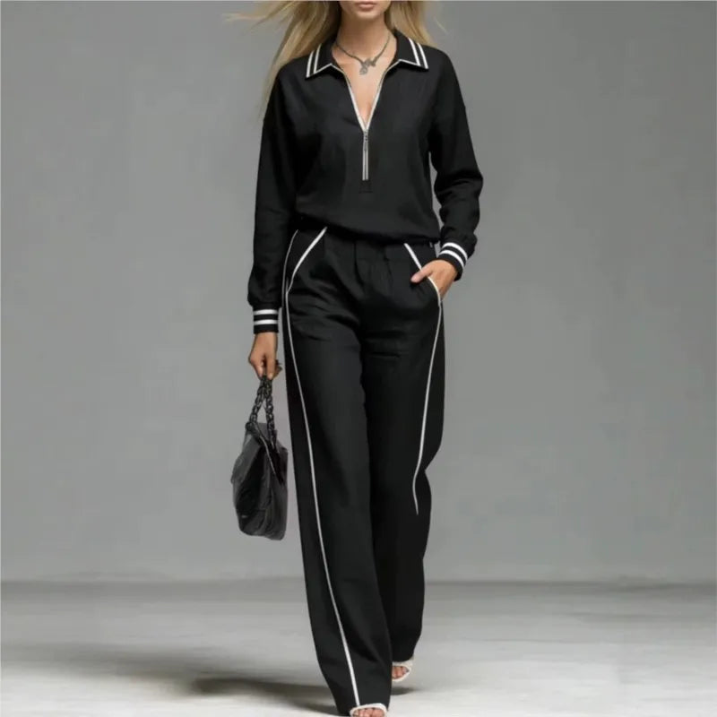 Woman wearing black half-zip two piece pant set with contrast stripe trim