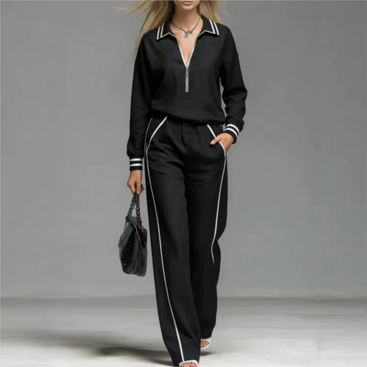 Woman wearing black half-zip two piece pant set with contrast stripe trim