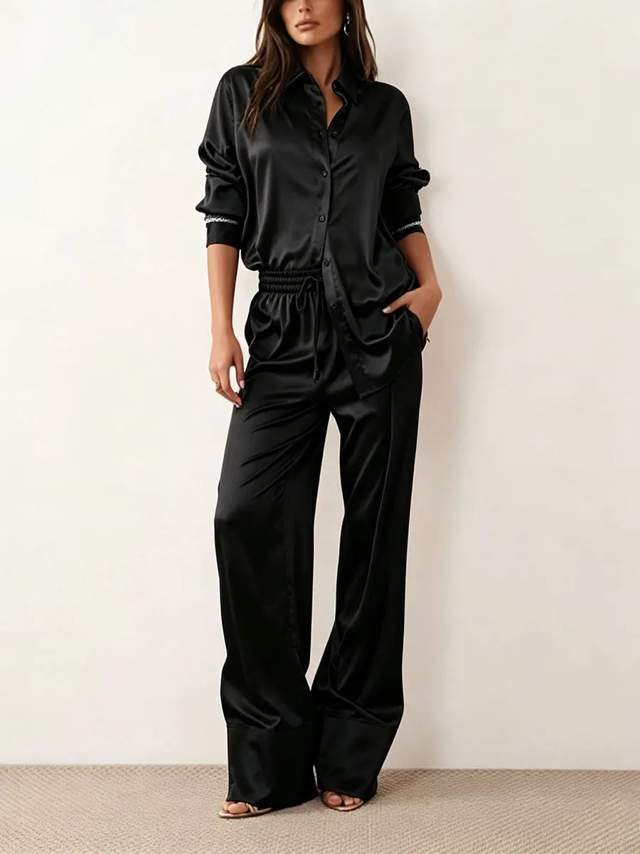 Woman wearing black satin shirt and wide leg pant set, front view