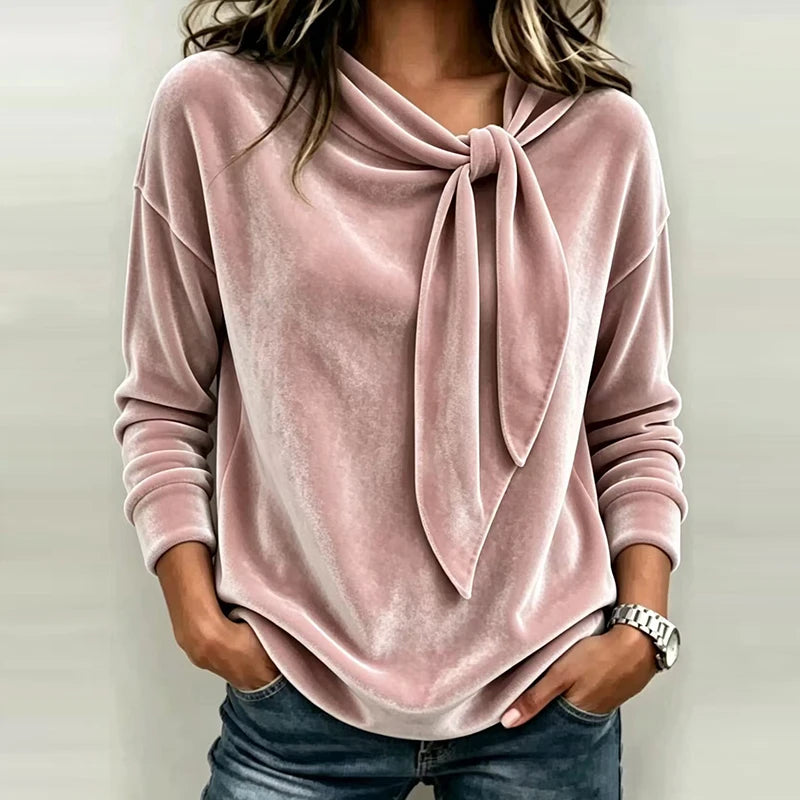 Woman wearing pink velvet bow neck pullover top