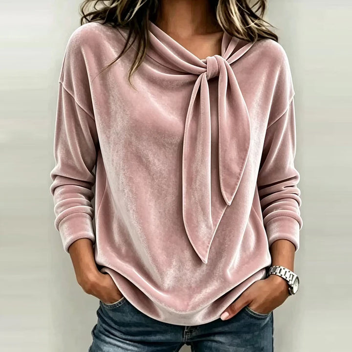 Woman wearing pink velvet bow neck pullover top