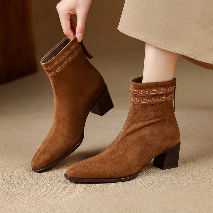 Woman wearing brown suede ankle boots with braided collar detail