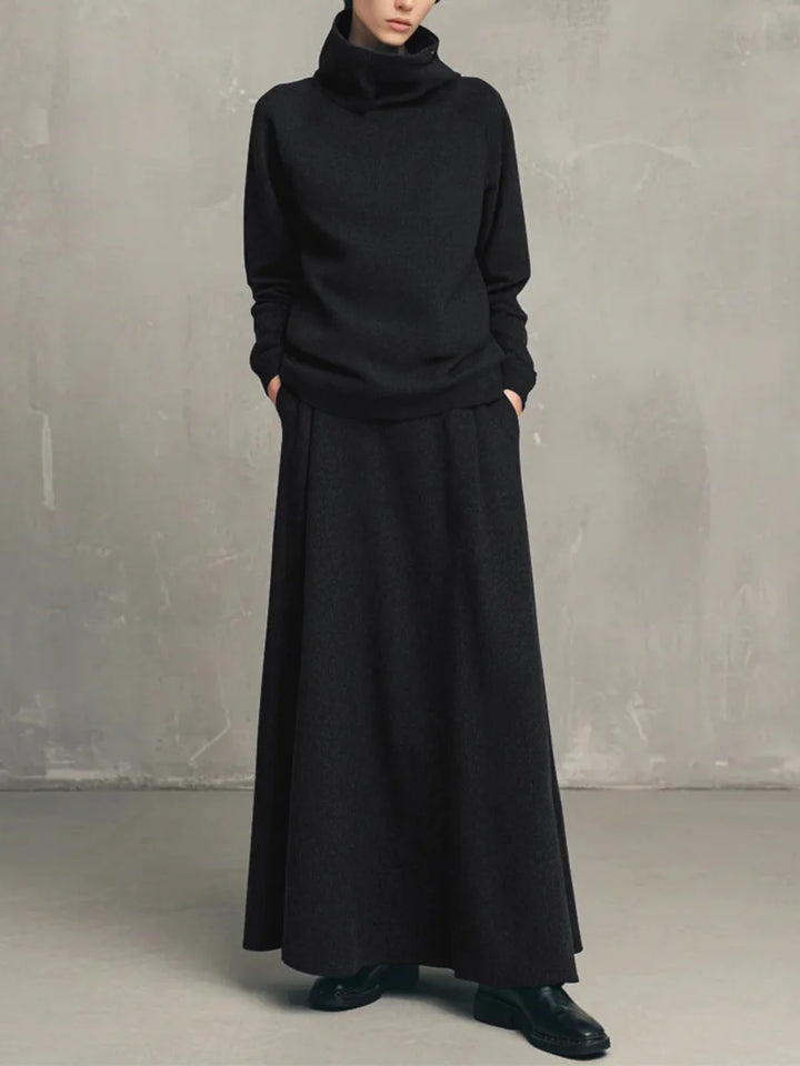 Woman wearing black funnel neck sweatshirt and matching maxi skirt set
