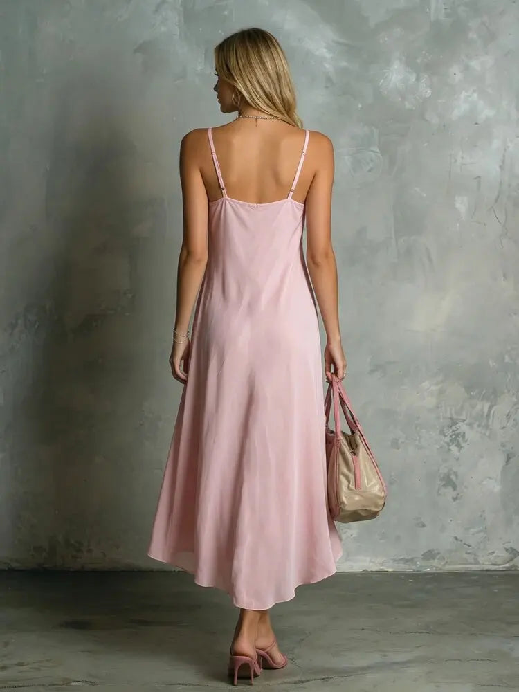 Back view of woman in pink halter midi dress showing spaghetti strap tie