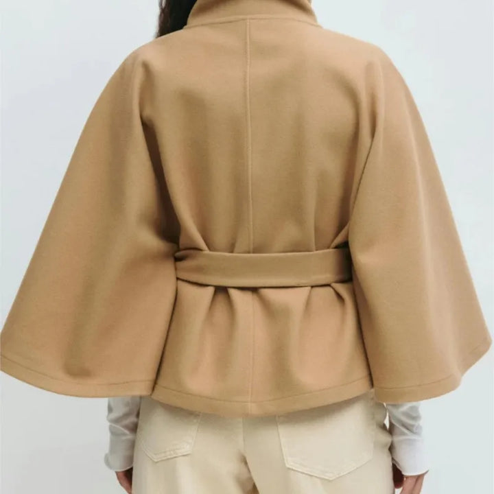 Back view of camel cape jacket showing belted waist and seaming