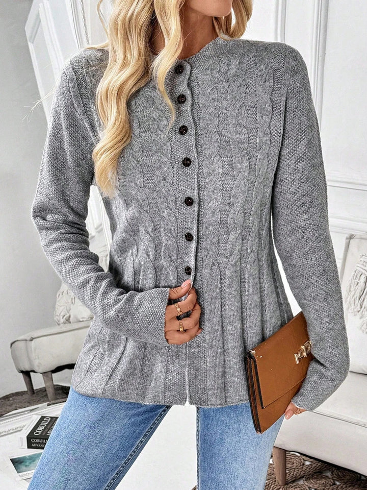 Close up front view of gray cable knit button cardigan with clutch