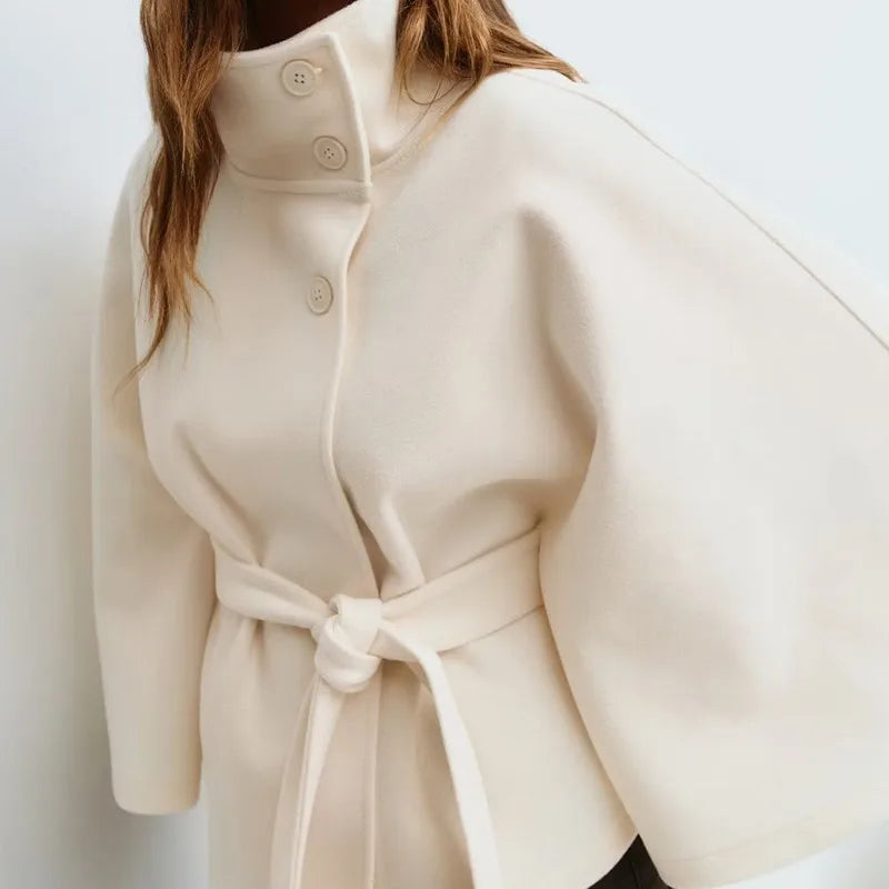 Close-up of ivory cape jacket collar and button closure