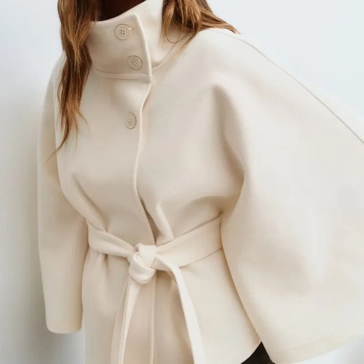 Close-up of ivory cape jacket collar and button closure
