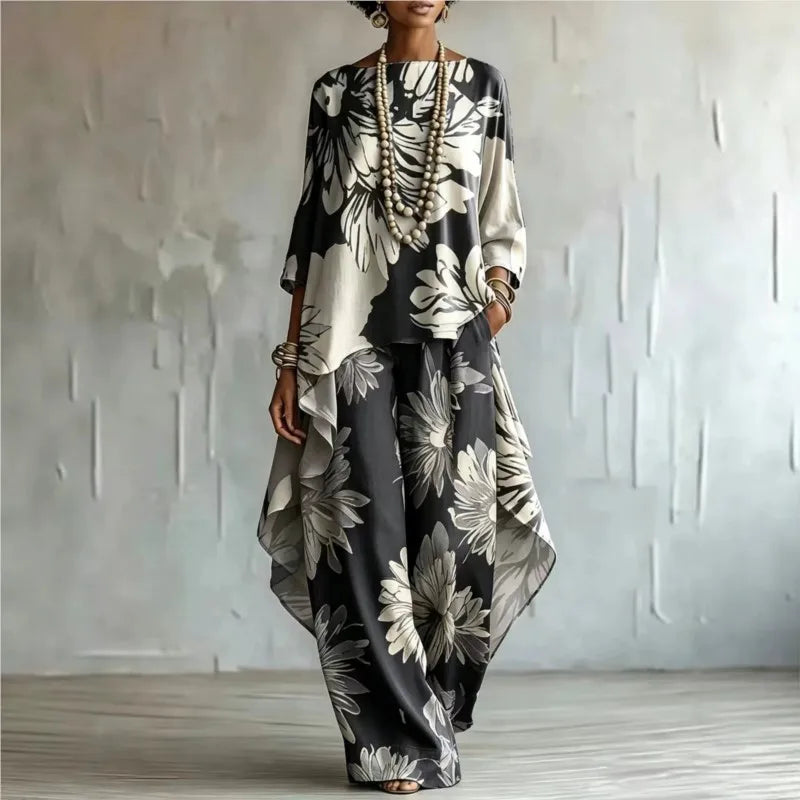 Woman wearing black floral two-piece set with asymmetric top and wide leg pants