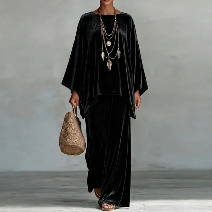 Woman wearing black velvet batwing top and wide leg pants set, front view