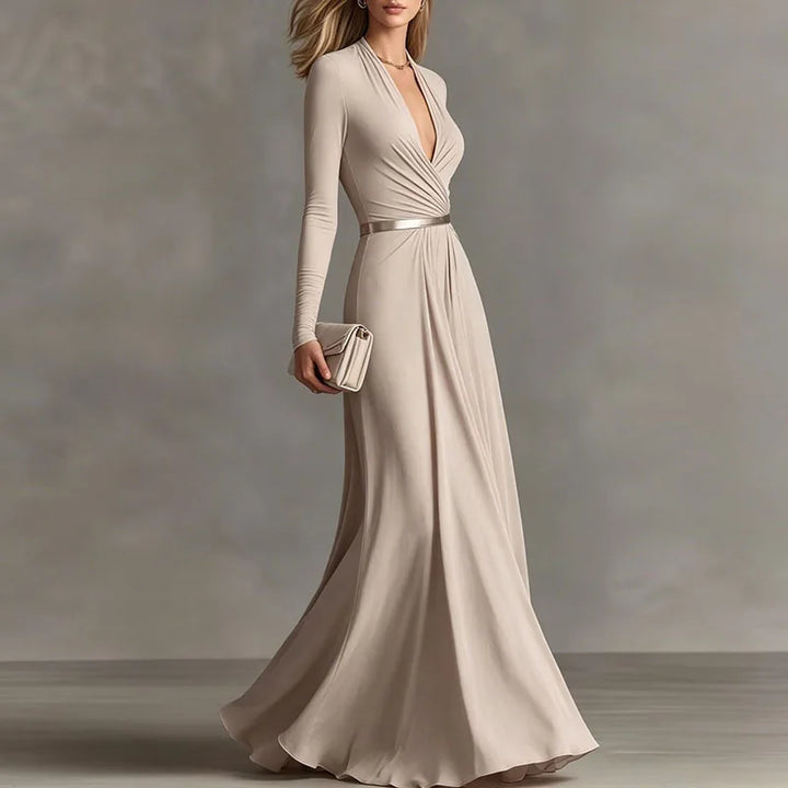 Woman in beige deep V-neck maxi dress with metallic belt, side view