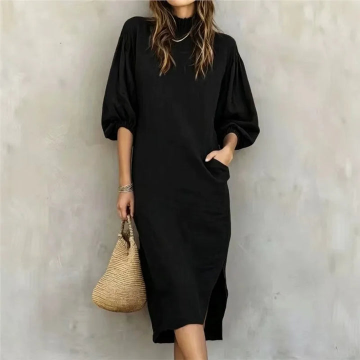 Woman wearing black mock neck midi dress with balloon sleeves, front view