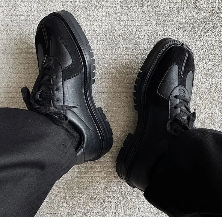 Close up of black Tabi sneakers with split toe detail on carpet