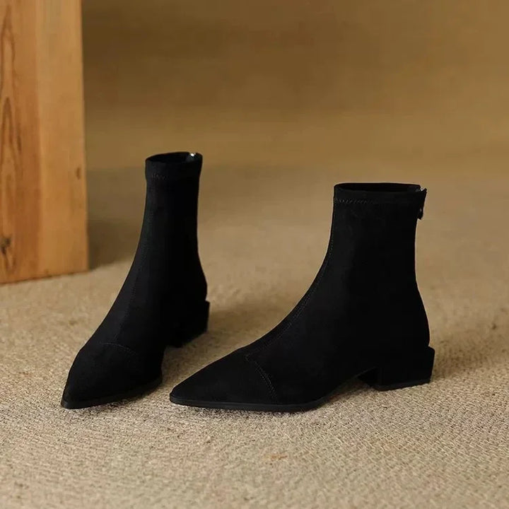 Pair of black suede ankle boots on floor