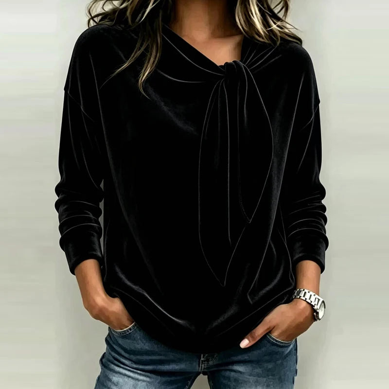 Woman wearing black velvet bow neck pullover top