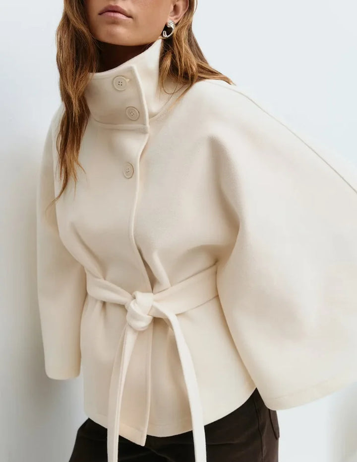 Close-up of ivory cape jacket collar buttons on model