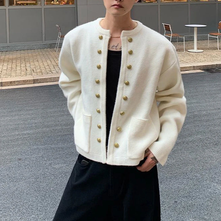 Man wearing white knit cardigan, front view with hands in pockets