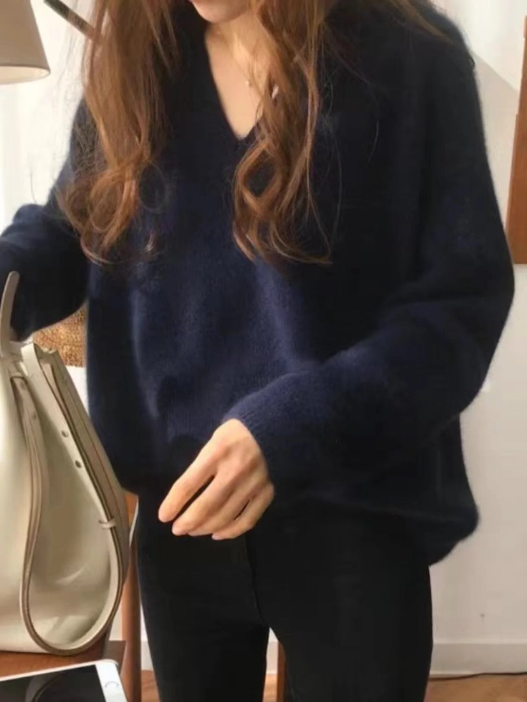 Woman wearing navy blue V-neck knit sweater