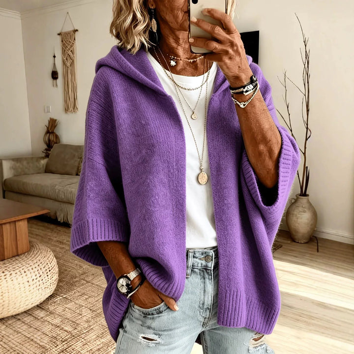 Woman wearing purple hooded poncho cardigan with batwing sleeves