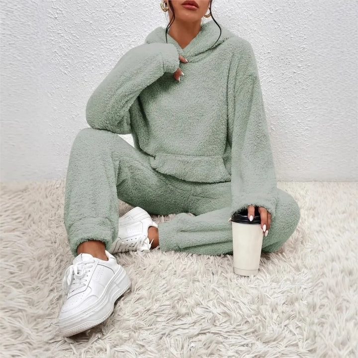 Woman wearing light green brushed fleece hooded loungewear set holding coffee