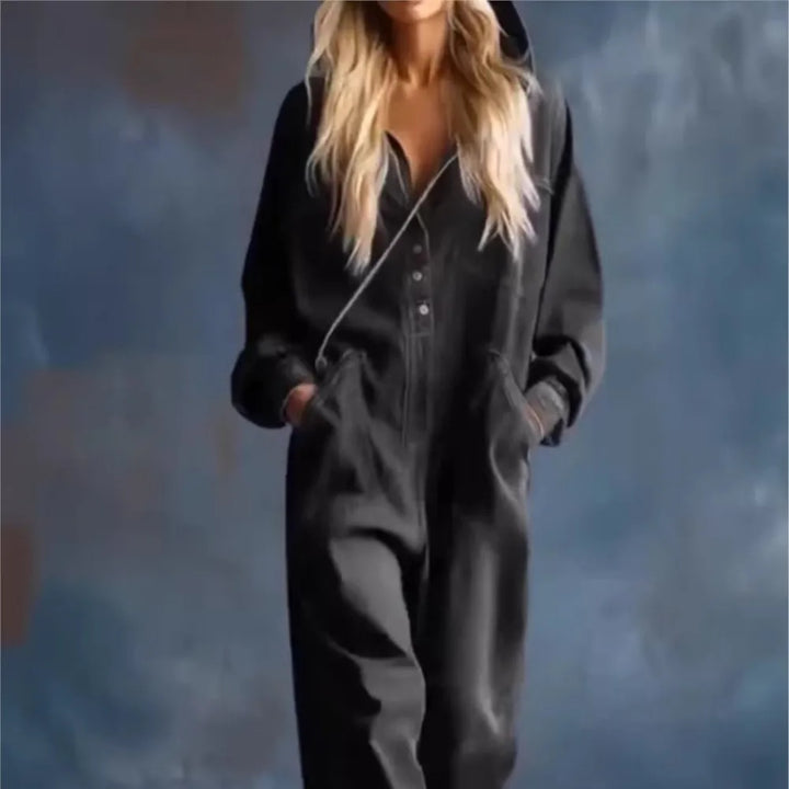 Woman wearing black hooded jumpsuit with hands in pockets