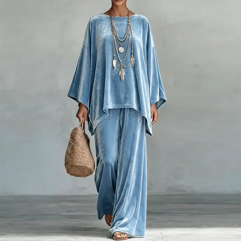 Woman wearing blue velvet batwing top and wide leg pants set, front view