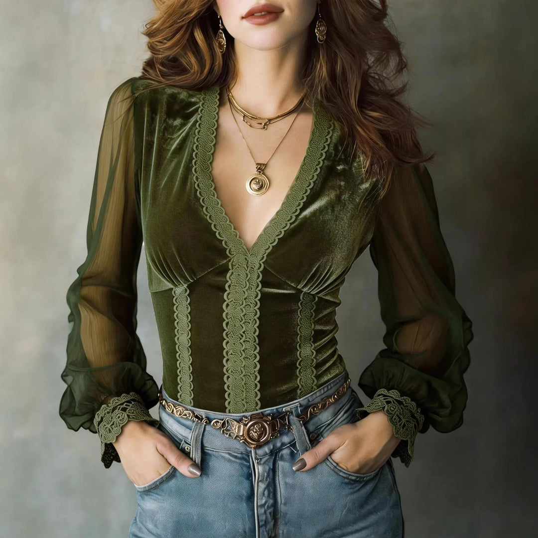 Woman wearing olive green velvet blouse with lace trim and sheer mesh sleeves