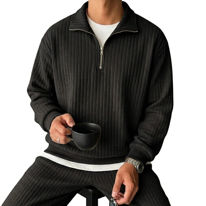 Man wearing black ribbed quarter-zip pullover, front view