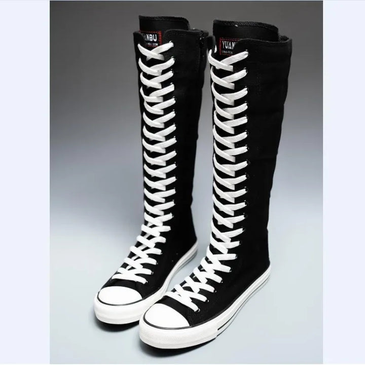 Black knee-high lace-up canvas boots with white laces, angled view
